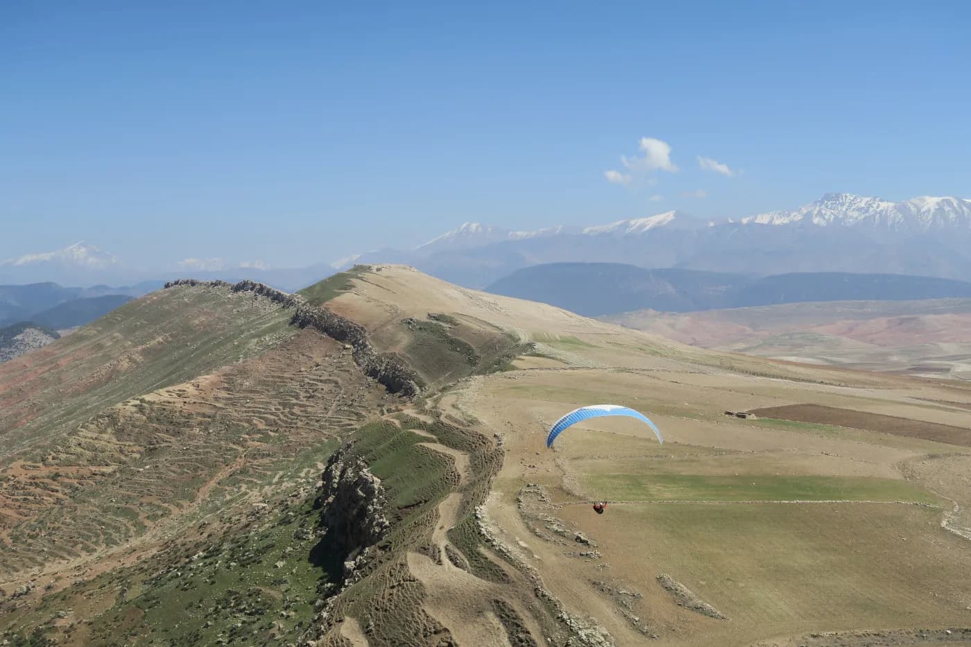 Paraglider flying over Aguergour, view over the Plateau du Kik, Morocco